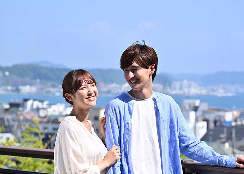 海を望む高題にいる男女の様子